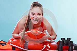 Happy lifeguard woman lying on rescue ring buoy.