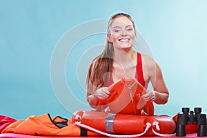 Happy lifeguard woman lying on rescue ring buoy.