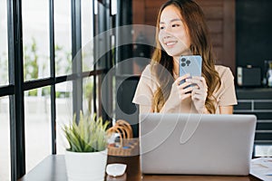 Happy lifestyle female smiling using smartphone in coffee shop
