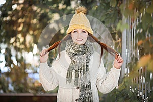 Happy lifestyle portrait of a beautiful model girl with a sweet smile in a warm autumn scarf