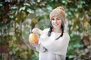 Happy lifestyle portrait of a beautiful young model woman with a pumpkin in her hands