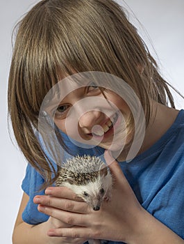 Happy litle girl with her pet African pygmy hedgehog