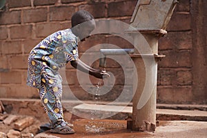 Happy Little African Boy Washing His Hands At the Village Pump