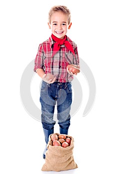 Happy little agriculturist boy showing potato harvest photo