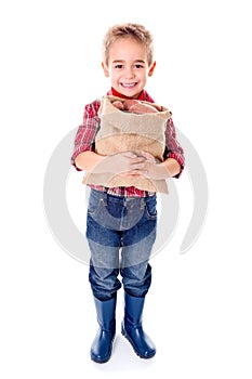 Happy little agriculturist holding potato harvest