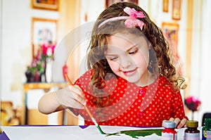 Happy little artistic girl painting