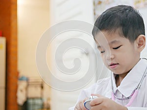 Happy little Asian baby getting dressed as a doctor