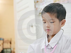 Happy little Asian baby getting dressed as a doctor