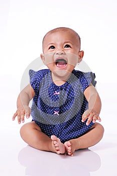 Happy little asian baby girl laughing sitting on white floor