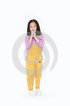 Happy little Asian child girl in dungarees expression hands implore isolated on white background