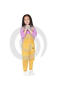 Happy little Asian child girl in dungarees expression hands implore isolated on white background photo