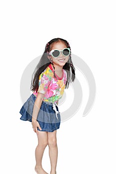 Happy little Asian kid girl wearing a flowers summer dress and sunglasses isolated on white background. Summer fashion kid concept