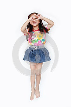 Happy little Asian kid girl wearing a flowers summer dress and sunglasses isolated on white background. Summer fashion kid concept