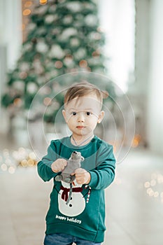 Happy little baby boy near Christmas tree