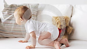 Happy little baby crawling along sofa at home 7