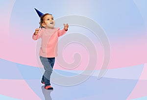 Happy little baby girl with birthday party hat