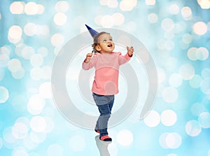 Happy little baby girl with birthday party hat