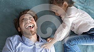 Happy little baby girl tickling laughing young father.