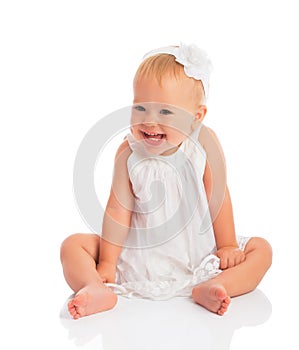 Happy little baby girl in white dress laughs isolated on white