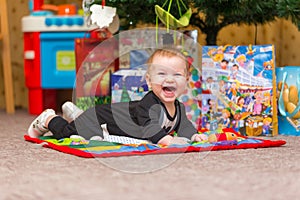Happy little baby with lots of New Year presents on the background