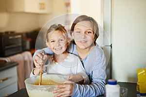 Happy little bakers. Portrait of two young siblings baking together at home.