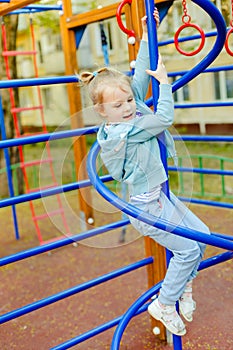 Happy little blonde girl having fun on a playground