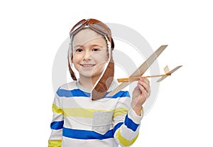 Happy little boy in aviator hat with airplane