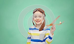 Happy little boy in aviator hat with airplane