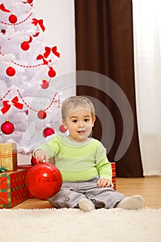 Happy little boy with big Christmas ornament