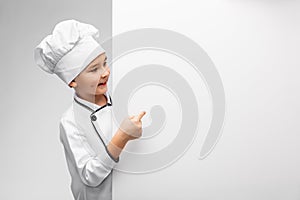 happy little boy in chef& x27;s toque with white board