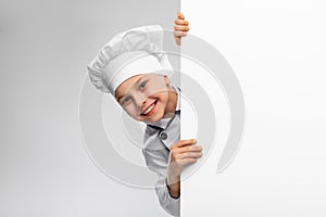happy little boy in chef& x27;s toque with white board