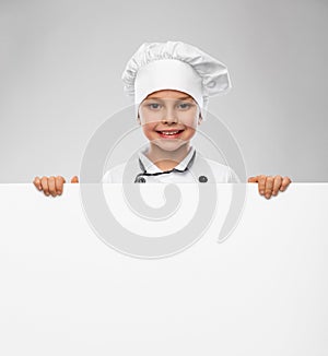 happy little boy in chef& x27;s toque with white board