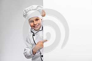 happy little boy in chef& x27;s toque with white board