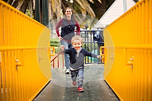 Happy little boy child and mother mom on the playground