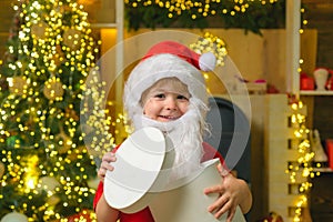 Happy little boy child with present or gift box indoors. Christmas kids portrait. Models child having fun with gift