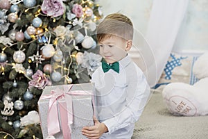 Happy little boy with Christmas gift. boy delighted with gift. Cute kid preparing home for xmas celebration. The concept of