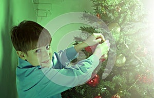 Happy little Boy decorate Christmas tree i