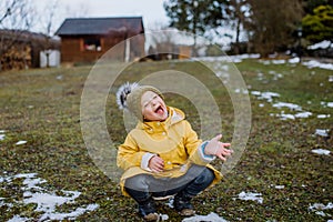 Happy little boy with Down syndrome outside in garden in wnter having fun. photo
