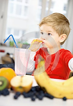 Happy Little Boy drinking a Healthy Smoothie in his Cozy home, w