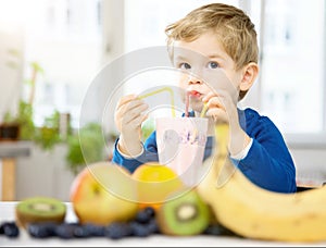 Happy Little Boy drinking a Healthy Smoothie in his Cozy home, w