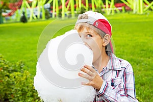 Happy little boy eating cotton candy