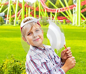 Happy little boy eating cotton candy