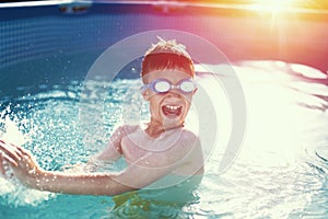 Happy little boy enjoying summer holiday in swimming pool