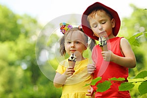 Happy little boy and girl eat sweet ice cream in