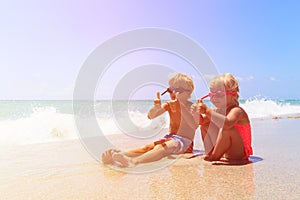 Happy little boy and girl play with water on beach