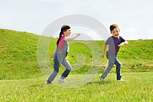 Happy little boy and girl running outdoors