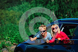 Happy little boy and girl travel by car