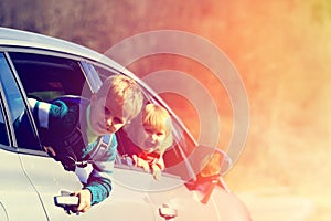 Happy little boy and girl travel by car in nature