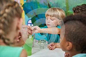 Happy little boy having fun with his friends at playroom.