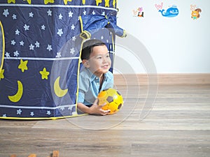 Happy little boy having fun with a play tent